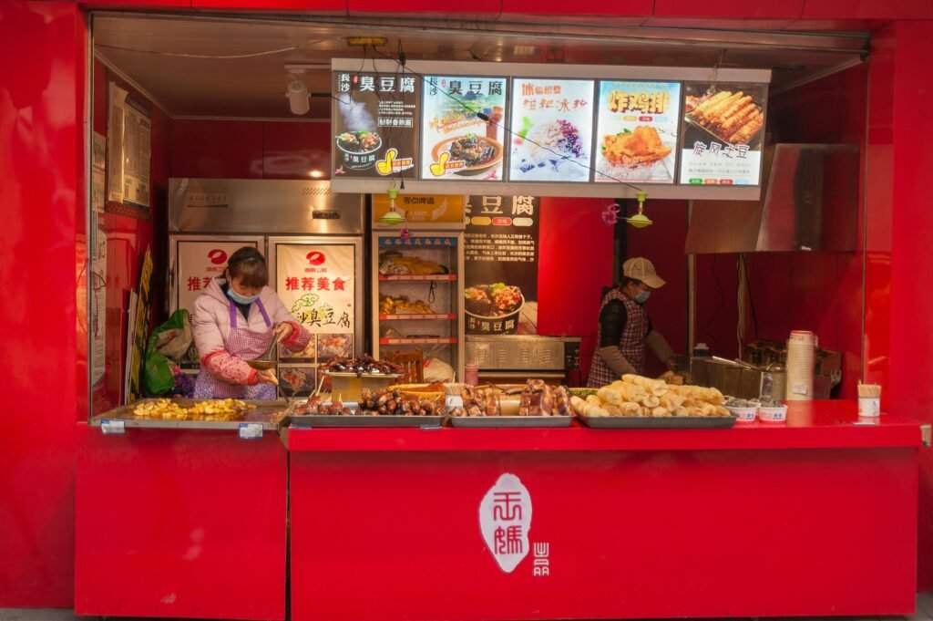 Vibrant street food stall with cooks preparing delicious traditional dishes.
